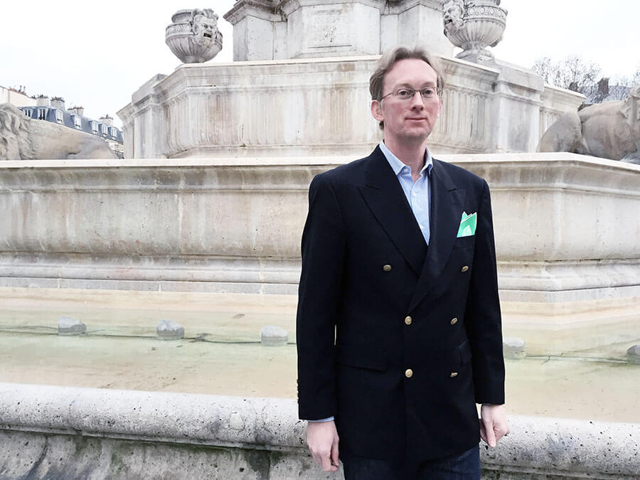 man in navy jacket with green pocket square