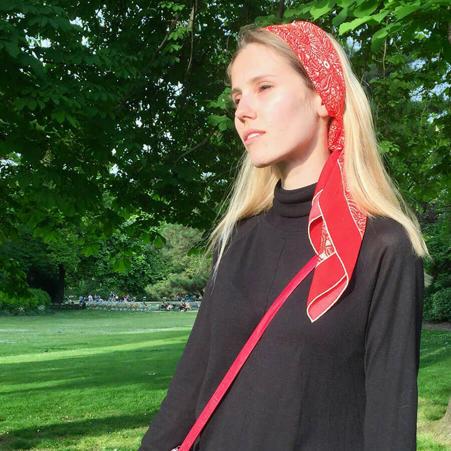 woman with red arabesque printed silk scarf worn on her head