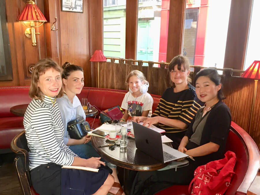 team working around a table in a parisienne cafe
