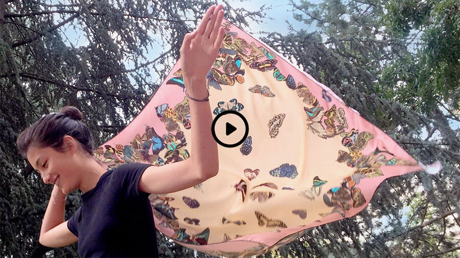 a woman with butterfly printed large pastel silk scarf flying
