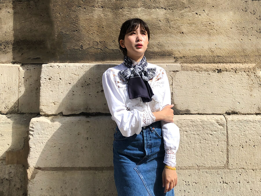 asian lady wearing white shirt with a long silk scarf, blue and white, bandan style, tied around her neck