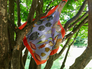 printed silk scarf with colorful fish hanging on tree