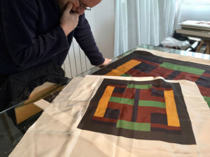 artist examining the silk scarf strike-offs