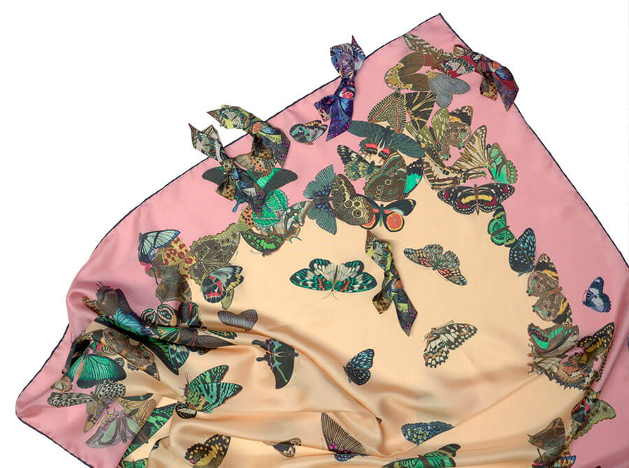 detail of all over butterfly printed silk scarf and silk bow broach