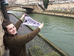 young woman holding artist collaboration silk scarf over the river Seine