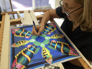 woman embroidering a silk scarf