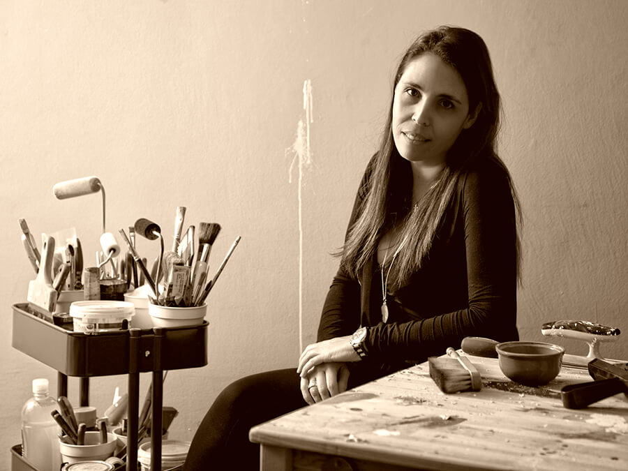 femme artiste assise à côté de pinceaux et feuilles de papier