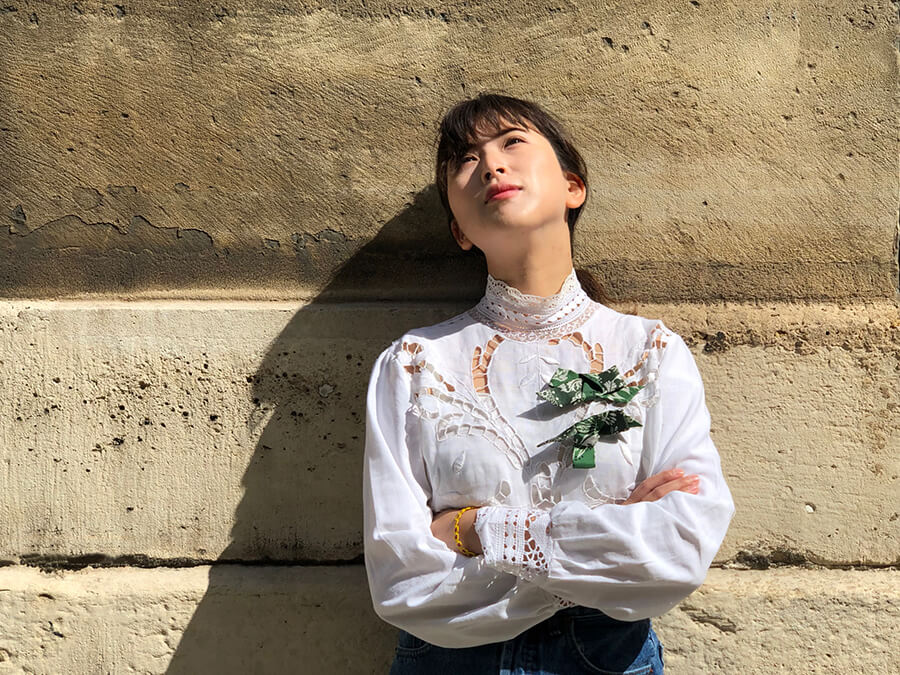 asian lady wearing white shirt wearing two green bowbroaches on her wrist