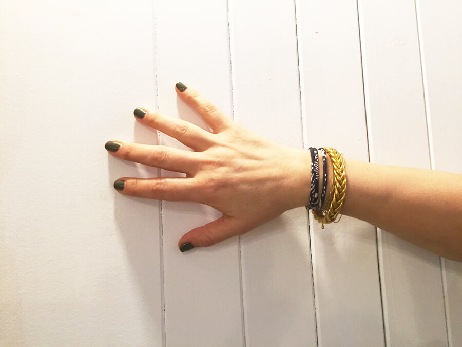 hand and wrist with blue printed silk bracelet with white background