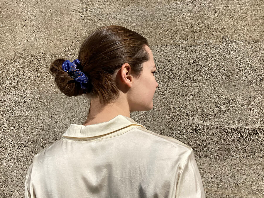 parisian lady wearing white shirt with a blue and starry hairscrunchy around her hair