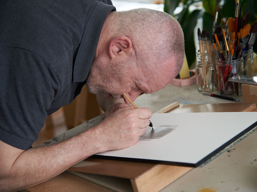 artiste peignant sur une feuille de papier blanche