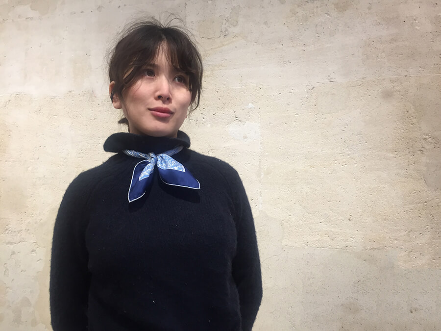 jeune femme asiatique portant un foulard en soie bleu noué autour du cou et un pull noir