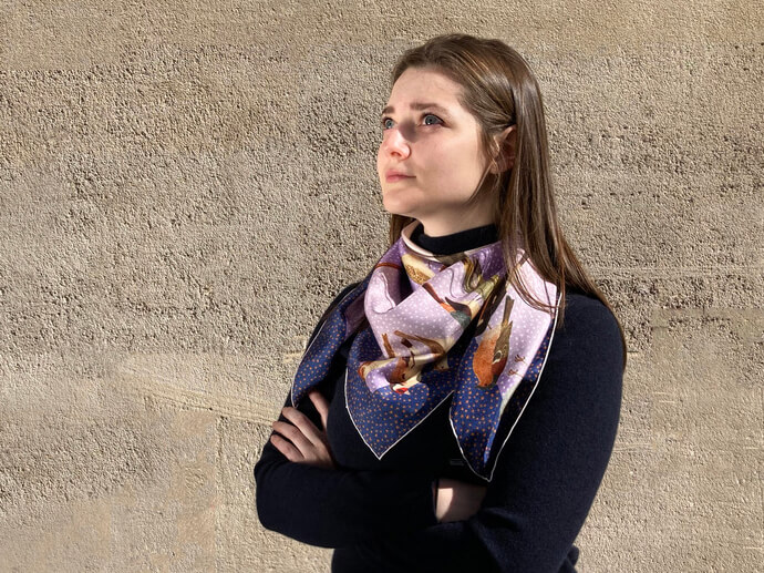 woman wearing bird and star printed lavender blue silk scarf