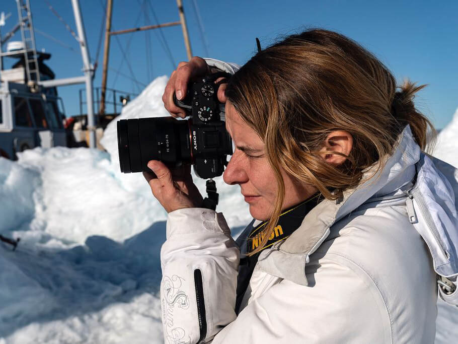 young lady taking a picture with snow in the background