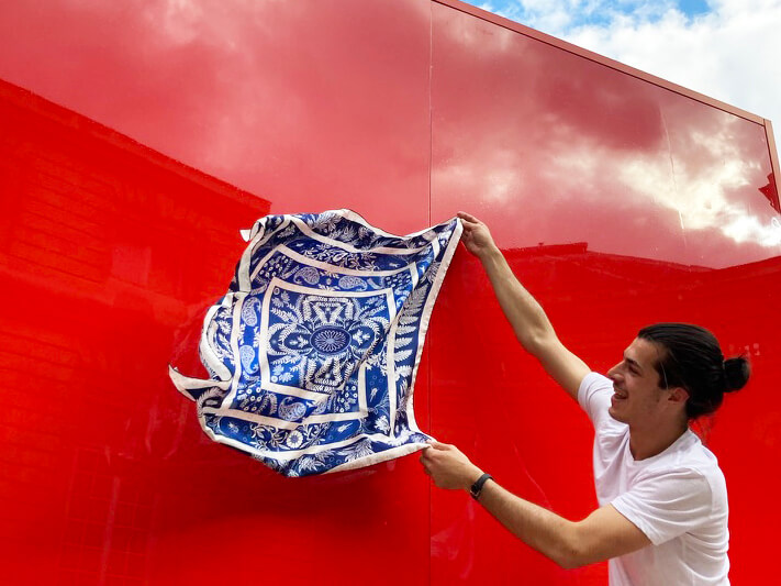 bandana printed bleu and white silk scarf on a red background