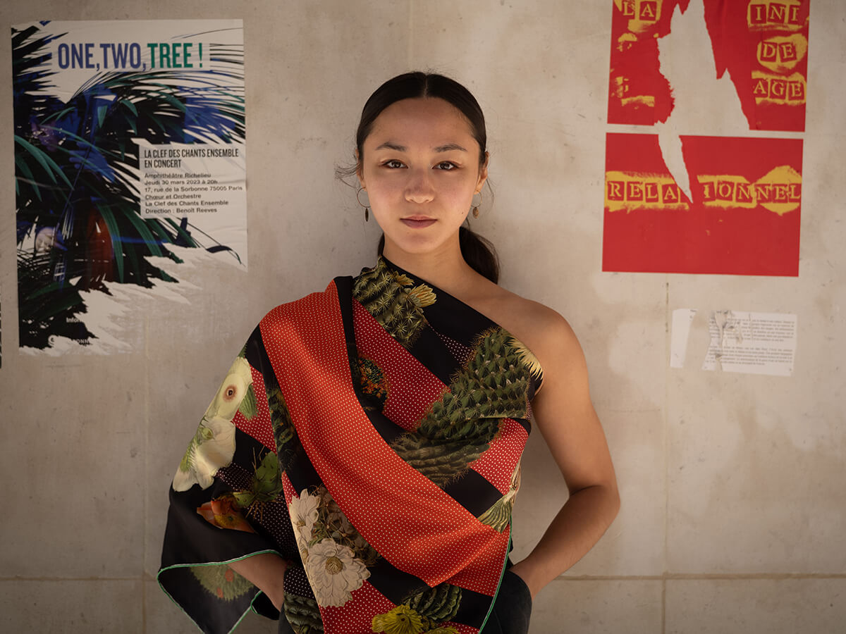 young lady wearing a cotton silk scarf, black and red with cactus motif around her chest