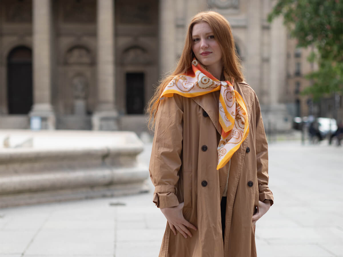 red hair woman with a cotton-silk scarf around her shoulders in front of a church in Paris